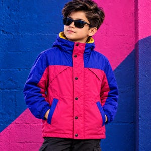 May include: A hooded jacket featuring a vibrant color-blocked design with a bright pink torso, royal blue sleeves and upper chest panel, and a yellow interior lining. The jacket includes a front button placket and two side pockets.