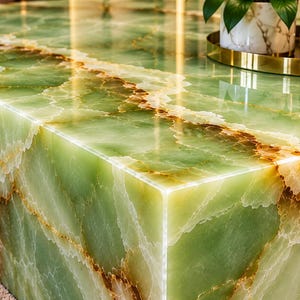 May include: A rectangular coffee table crafted from polished green onyx stone, featuring prominent white and brown veining throughout its surface. The table has a smooth, reflective finish with sharp, clean edges and a solid, block-like structure.