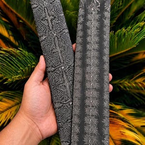 May include: Two rectangular metal bars featuring intricate, contrasting patterns. The left bar displays a dark gray grid-like design with cross motifs, while the right bar shows a central vertical column of detailed, repeating floral-like engravings.