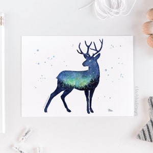 May include: Watercolor painting of a deer silhouette with a starry night sky and aurora borealis inside. The deer is facing right and has a dark blue outline. The background is white with a few light blue dots.