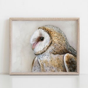 May include: A watercolor painting of a barn owl with brown and white feathers. The owl is looking to the left of the image. The painting is framed in a light wood frame.