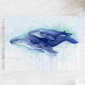 May include: Watercolor painting of two humpback whales swimming together in a blue and green ocean. The whales are painted in a realistic style with detailed features. The painting is set against a background of blue and green watercolor washes.