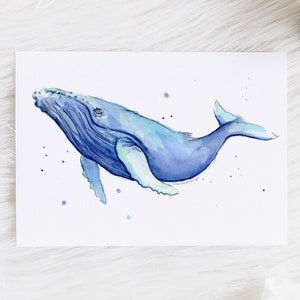 May include: Watercolor painting of a blue whale swimming in a light blue ocean. The whale is facing the right side of the image and has a white underbelly. The painting is on a white background.