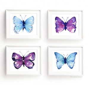 May include: Set of four watercolor paintings of butterflies. Two butterflies are blue and two are purple.