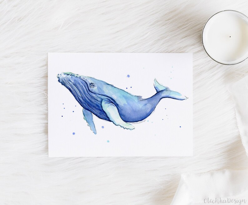 May include: Watercolor painting of a blue whale swimming in a light blue ocean. The whale is facing the right side of the image and has a white underbelly. The painting is on a white background.