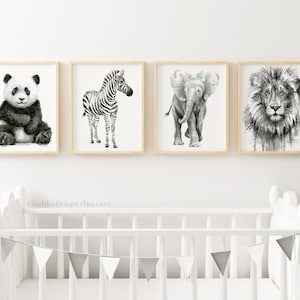 May include: Set of four black and white animal illustrations in wooden frames. The illustrations depict a panda, zebra, elephant, and lion.