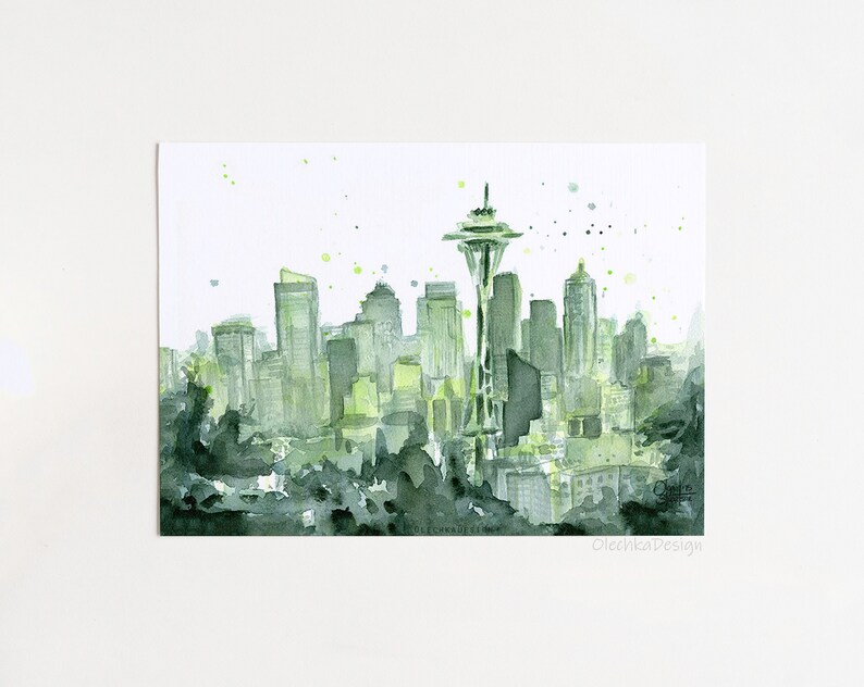May include: Watercolor painting of a cityscape in shades of green and gray. The Space Needle is the focal point, with other buildings in the background. The artwork has a soft, artistic feel, with splatters of green paint.