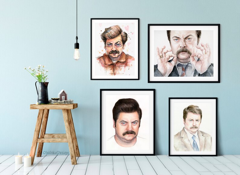 May include: Four framed watercolor paintings of a man with a mustache. The man is depicted in different poses and expressions. The paintings are all in black frames and are hanging on a light blue wall.