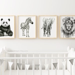 May include: Four framed animal art prints in black and white. The prints feature a panda, zebra, elephant, and lion. The frames are light wood, and the artwork is displayed above a white crib with a gray and white pennant banner.