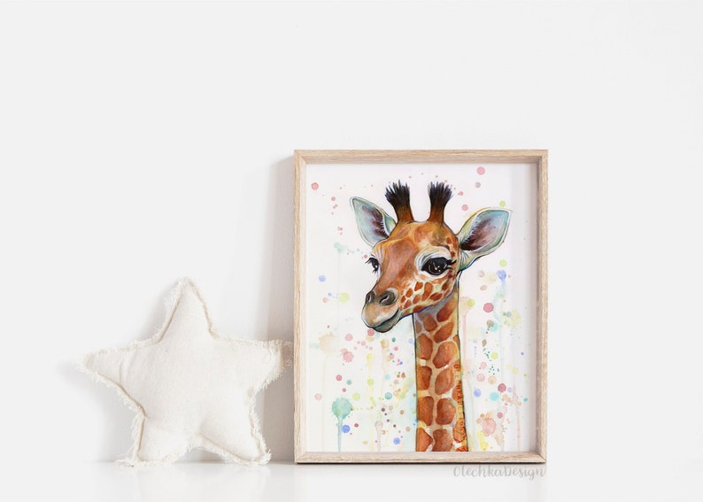 May include: Watercolor painting of a baby giraffe with a light brown and orange spotted pattern. The giraffe is looking at the viewer with big brown eyes. The background is a light pink with colorful watercolor splatters.