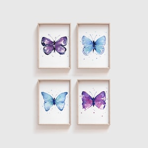 May include: Set of four watercolor butterfly prints in shades of blue and purple. Each print features a single butterfly with white dots on a white background.