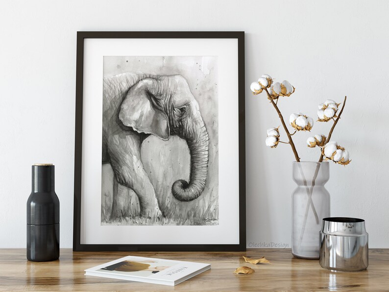May include: Black and white watercolour painting of an elephant's head and trunk. The elephant is facing left and its trunk is curled up. The background is a light grey with a watercolour wash.