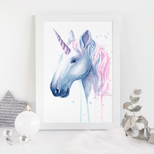 Pode incluir: Pintura em aquarela da cabe&ccedil;a de um unic&oacute;rnio com uma juba rosa e azul e um chifre roxo. O fundo &eacute; branco com respingos de aquarela azul e rosa.