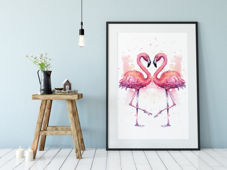 May include: A watercolor painting of two pink flamingos facing each other with their necks forming a heart shape. The background is a soft pink watercolor wash.