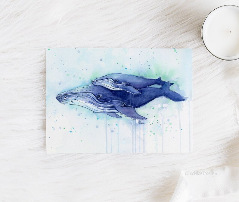 May include: Watercolor painting of two humpback whales swimming together in a blue and green ocean. The whales are painted in a realistic style with detailed features. The painting is set against a background of blue and green watercolor washes.