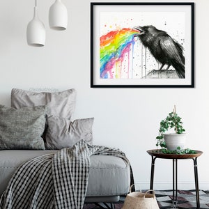 May include: A black and white watercolor painting of a raven with a rainbow coming out of its mouth. The raven is perched on a rock and the rainbow is dripping down.