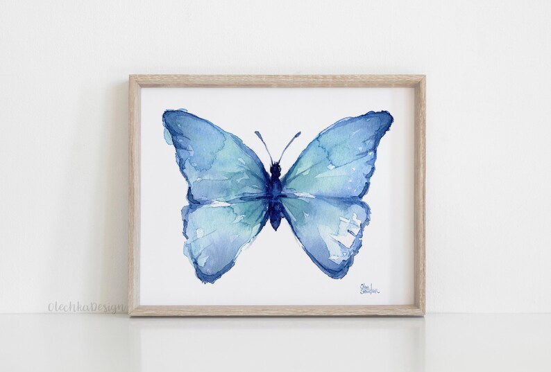 May include: A watercolor painting of a blue butterfly with its wings spread open. The butterfly is painted in shades of blue and green, and the background is white.