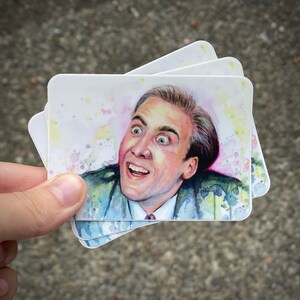 Op de afbeelding: Een aquarel van een man met een verraste uitdrukking. De schildering is op een witte achtergrond met spatten van roze en blauwe verf.