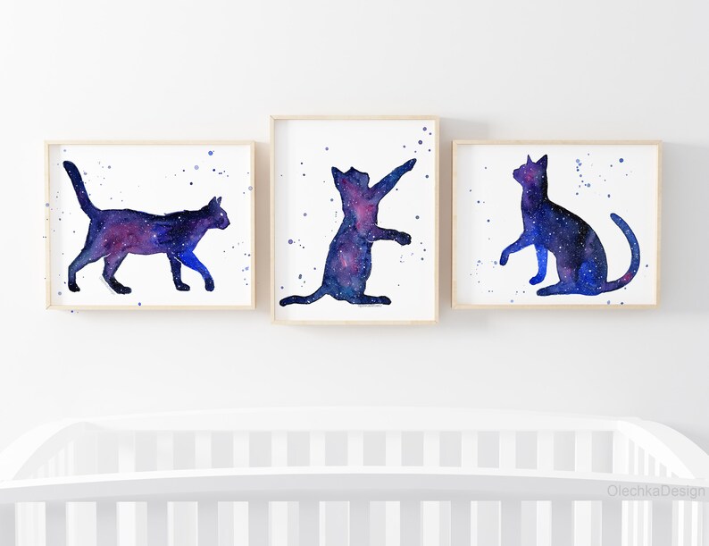 Pode incluir: Tr&ecirc;s pinturas de aquarela de gatos gal&aacute;xia. Cada gato est&aacute; em uma pose diferente, com um padr&atilde;o de gal&aacute;xia azul e roxo.
