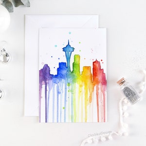 May include: Watercolor painting of the Seattle skyline in rainbow colors with the Space Needle in the center. The painting has a dripping effect, creating a unique and colorful design.