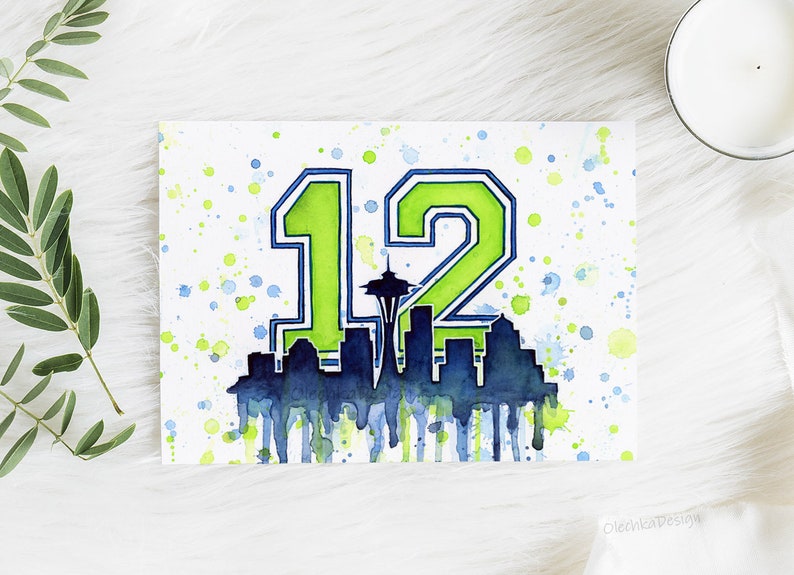May include: Watercolor painting of the number 12 in green and blue with a silhouette of the Seattle skyline, including the Space Needle, in the center. The background is white with green and blue watercolor splatters.