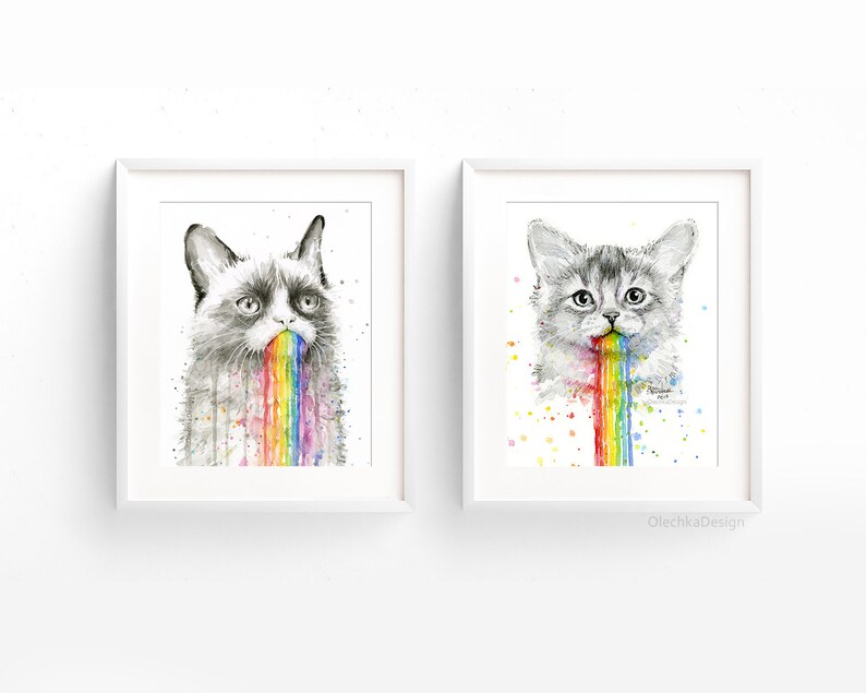 May include: Two framed watercolor paintings of cats vomiting rainbows. The cat on the left is a grumpy cat with a black and white face. The cat on the right is a white cat with gray markings. Both cats have a rainbow coming out of their mouths.