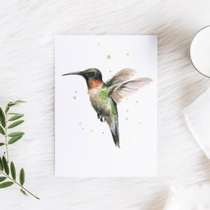 May include: Watercolor painting of a hummingbird in flight with green, red, and brown feathers. The background is white with small green, yellow, and gray dots.