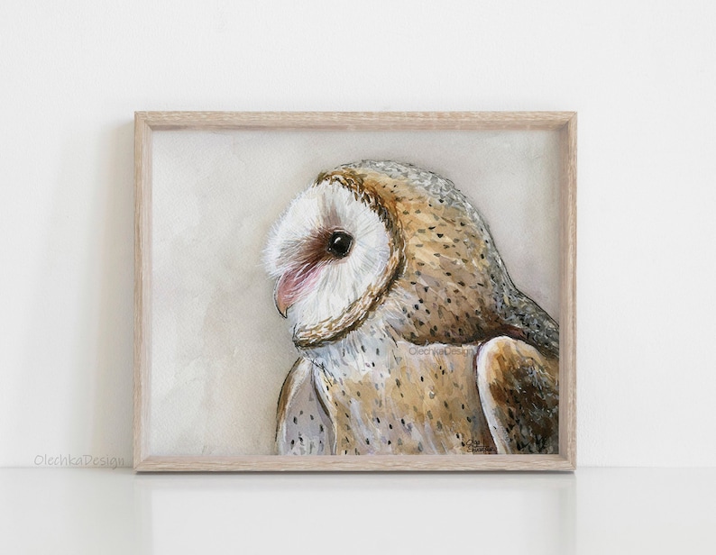 May include: A watercolor painting of a barn owl with brown and white feathers. The owl is looking to the left of the image. The painting is framed in a light wood frame.
