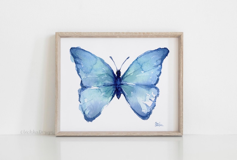 May include: A watercolor painting of a blue butterfly with its wings spread open. The butterfly is painted in shades of blue and green, and the background is white.