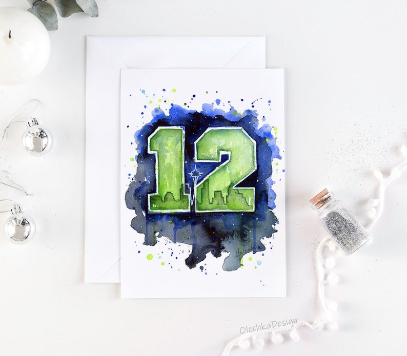 May include: Watercolor greeting card featuring the number 12 in green, with a cityscape silhouette and a star. The number is set against a dark blue and green watercolor splash background. The card is on a white background.