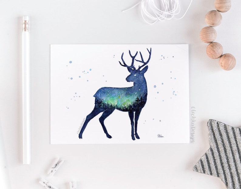 May include: Watercolor painting of a deer silhouette with a starry night sky and aurora borealis inside. The deer is facing right and has a dark blue outline. The background is white with a few light blue dots.