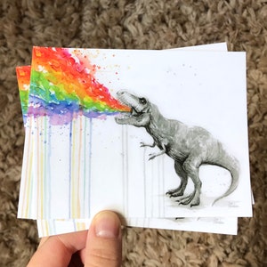 May include: A watercolor painting of a dinosaur breathing out a rainbow. The dinosaur is gray and has a white background. The rainbow is colorful and has a watercolor effect.