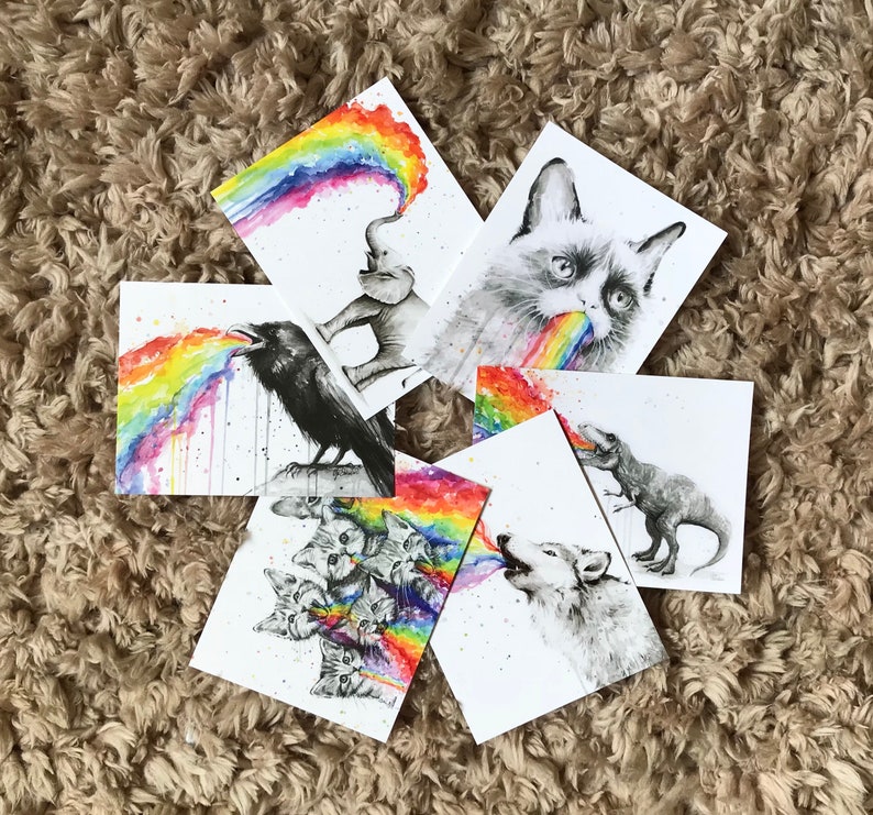 May include: Set of six illustrated cards featuring various animals blowing rainbows. The animals include a raven, a cat, a wolf, a dinosaur, an elephant, and a group of kittens.