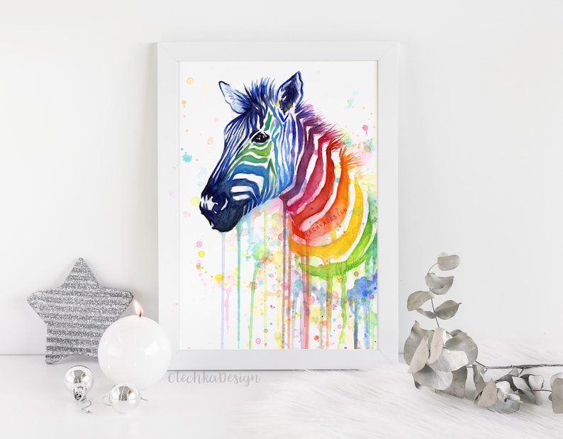 K&ouml;nnte beinhalten: Aquarellmalerei eines Zebras mit einem Regenbogenmuster. Das Zebra blickt nach links und hat einen wei&szlig;en Hintergrund mit bunten Aquarellspritzern.