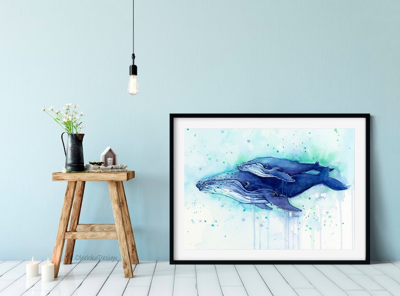 May include: Watercolor painting of a mother and baby humpback whale swimming in a blue and green ocean. The painting is framed in black and has a white mat.