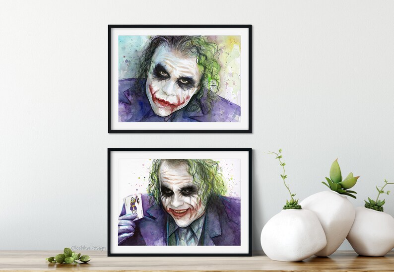 May include: Two watercolour paintings of the Joker from the film The Dark Knight. The first painting shows the Joker's face with a sinister smile. The second painting shows the Joker holding a playing card with the Joker's face on it.