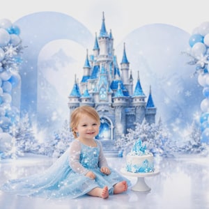 May include: A young child in a light blue dress sits in front of a winter-themed backdrop. A castle, balloons, and a cake with a blue and white design are visible. The scene evokes a fairytale or birthday party theme.