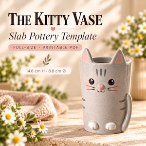 Pode incluir: Um vaso de cerâmica cinza em forma de gato com orelhas rosas, nariz rosa e patas brancas. O texto diz: THE KITTY VASE Slab Pottery Template FULL-SIZE PRINTABLE PDF 14.8 cm H 8.8 cm Ø. O vaso apresenta um acabamento salpicado e uma cauda de gato.