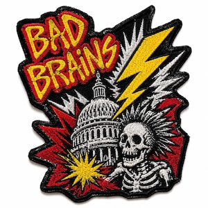 May include: An embroidered patch featuring the text BAD BRAINS in yellow with red outlines. The design includes a white illustration of the United States Capitol building, a yellow lightning bolt, and a white skeleton with a mohawk on a red background.