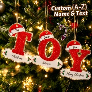 Puede incluir: Tres adornos navideños colgantes con forma de letras J, O y Y. Cada letra es roja con textura brillante, rematada con un gorro de Papá Noel rojo y blanco, y cuenta con una base blanca con detalles de acebo y texto personalizado.