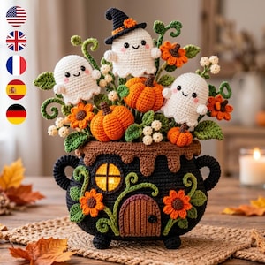 May include: A crochet arrangement featuring three white ghosts, one wearing a black hat, nestled among orange pumpkins, green leaves, and orange flowers. The base is a black crochet cauldron with a small door and a glowing yellow window.