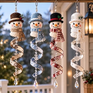 May include: Four hanging crochet snowman ornaments, each wearing a hat and scarf in brown, blue, black, or white. Below each snowman is a spiral ribbon featuring snowflake patterns, a vertical string of clear beads, and a pointed crystal pendant.