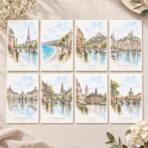 May include: A set of eight rectangular art prints featuring watercolor illustrations of French cities including Paris, Nice, Lyon, Marseille, Bordeaux, Strasbourg, Lille, and Toulouse. Each print displays a landmark, city name, and France text.
