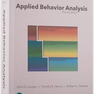 May include: A light grey textbook titled Applied Behavior Analysis Third Edition by John O. Cooper, Timothy E. Heron, and William L. Heward. The cover features a central graphic with horizontal bands of red, orange, yellow, green, blue, and purple.