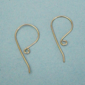 Può includere: Due ganci per orecchini dorati. I ganci sono in metallo e hanno un design semplice ed elegante.