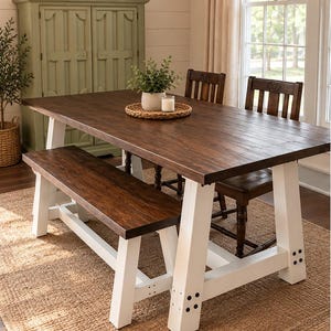 May include: A rectangular dining table with a dark brown wooden top and white A-frame legs, accompanied by a matching wooden bench and two dark brown wooden chairs. The table features visible black bolt accents on the white base structure.