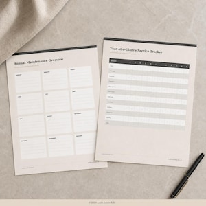 以下が含まれることがあります： Annual Maintenance OverviewとYear-at-a-Glance Service Trackerと書かれた2枚の印刷用紙。書類はベージュの背景に黒い文字とグリッド線が引かれています。用紙の右側には黒いペンが置かれています。