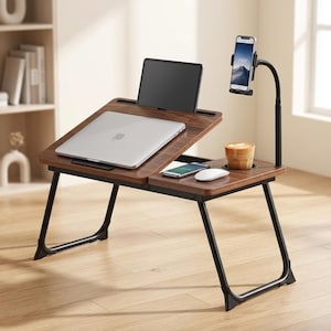 May include: A portable laptop desk with a dark wood grain surface and black metal legs. It features an adjustable tilting platform, a built-in cup holder, a smartphone mount on a flexible arm, a silver laptop, a tablet, a smartphone, and a mouse.