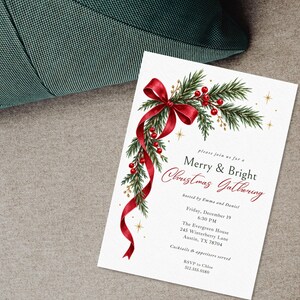 K&ouml;nnte beinhalten: Eine wei&szlig;e, rechteckige Einladungskarte mit einer Aquarellillustration aus gr&uuml;nen Tannenzweigen, roten Beeren und einem flie&szlig;enden roten Band. Der Text lautet: please join us for a Merry & Bright Christmas Gathering, hosted by Emma and Daniel.