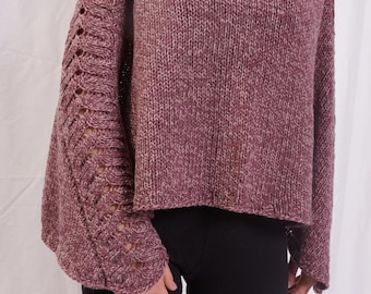 Può includere: Un maglione lavorato a maglia color malva con scollo a barchetta e dettagli traforati sulle maniche. Il maglione ha una vestibilità ampia ed è realizzato con un filato strutturato. Le maniche presentano un motivo decorativo con piccole aperture.